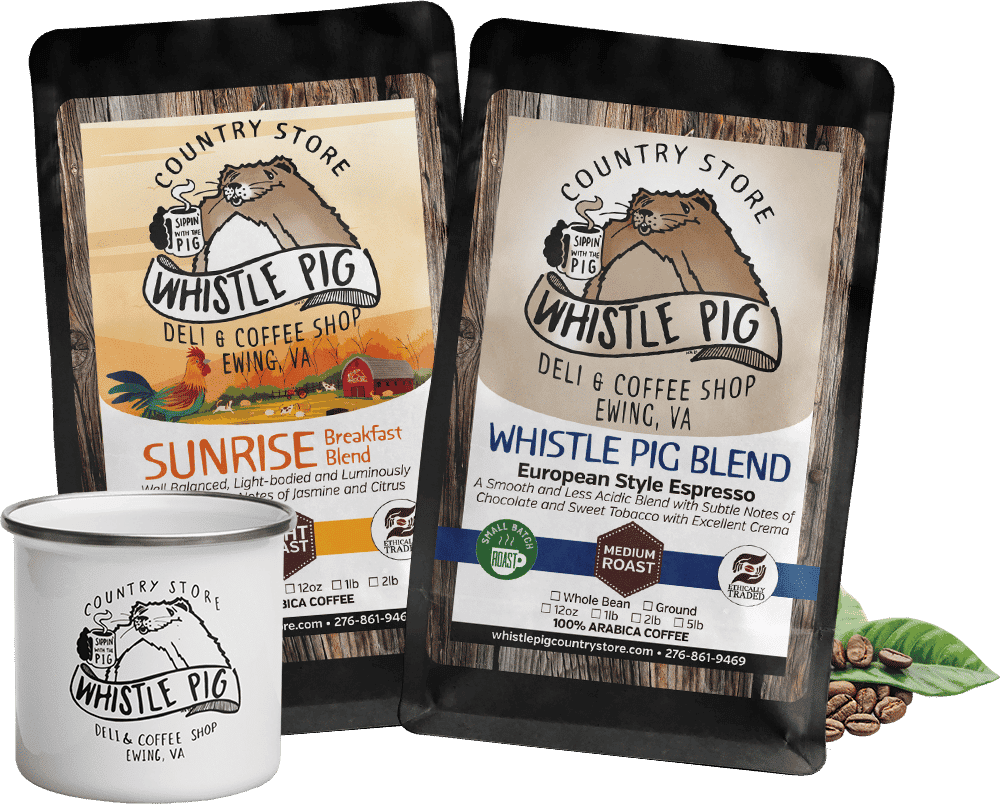 Two bags of Whistle Pig Country Store coffee, Winter Blend and American Style Espresso with a white coffee much with the Whistle Pig logo on it and a few scattered coffee beans behind the right bag of coffee